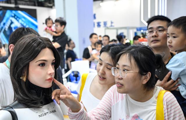 (260822) -- BEIJING, Aug. 22, 2026 (Xinhua) -- People view a humanoid robot at the 2026 World Robot Conference in Beijing, capital of China, Aug. 22, 2026. The conference, which runs from Wednesday through Sunday, has drawn more than 300 exhibitors from 26 countries, with over 3,000 products on display, including more than 300 debuts. Many people visited the conference on Saturday, the first open day of the event. (Xinhua/Chen Yehua)