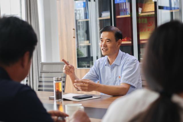 (260822) -- LIANYUNGANG, Aug. 22, 2026 (Xinhua) -- Zhong Baijun discusses development plans with representatives of neighboring villages at a circular economy industrial park in Xijidang Village, Zhewang Town of Lianyungang City, east China's Jiangsu Province, Aug. 19, 2026. Zhong Baijun, Party secretary of Xijidang Village and head of the village committee, has spent 28 years serving his hometown in Zhewang Town of Lianyungang City, east China's Jiangsu Province.
  When he returned to the village to take up his post in 1998, the village collective had no industries and was in debt. Most residents made a living from farming, and many younger villagers left home to seek work elsewhere.
  Looking for new ways to develop the local economy, Zhong and other village officials traveled to other areas to explore potential industries. Leveraging the village's coastal location and the relatively abundant stock of discarded fishing nets, they gradually developed a nylon pellet processing industry.
  The industry initially grew through small workshops. To restructure the sector, the village invested 120 million yuan (about 17.9 million U.S. dollars) in building a standardized industrial park and later developed a model that allowed residents to benefit from the industry's growth through shareholding, local employment and dividends. By 2025, Xijidang's total industrial output reached 2.5 billion yuan (about 372 million U.S. dollars). The industry also created jobs for more than 1,600 local residents.
  As the collective economy grew, the village put more resources into improving community well-being. It organized cultural and sports activities, as well as model-family award campaigns, giving residents more opportunities to take part in community events.
  Over the past 28 years, Zhong has witnessed the village's industries expand, employment opportunities increase and collective income rise. "We should put the people's concerns first," Zhong said. (Photo by Si Wei/Xinhua)