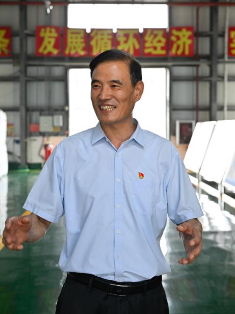 (260822) -- LIANYUNGANG, Aug. 22, 2026 (Xinhua) -- Zhong Baijun talks about the company's development at a village collective company in Xijidang Village, Zhewang Town of Lianyungang City, east China's Jiangsu Province, Aug. 19, 2026. Zhong Baijun, Party secretary of Xijidang Village and head of the village committee, has spent 28 years serving his hometown in Zhewang Town of Lianyungang City, east China's Jiangsu Province.
  When he returned to the village to take up his post in 1998, the village collective had no industries and was in debt. Most residents made a living from farming, and many younger villagers left home to seek work elsewhere.
  Looking for new ways to develop the local economy, Zhong and other village officials traveled to other areas to explore potential industries. Leveraging the village's coastal location and the relatively abundant stock of discarded fishing nets, they gradually developed a nylon pellet processing industry.
  The industry initially grew through small workshops. To restructure the sector, the village invested 120 million yuan (about 17.9 million U.S. dollars) in building a standardized industrial park and later developed a model that allowed residents to benefit from the industry's growth through shareholding, local employment and dividends. By 2025, Xijidang's total industrial output reached 2.5 billion yuan (about 372 million U.S. dollars). The industry also created jobs for more than 1,600 local residents.
  As the collective economy grew, the village put more resources into improving community well-being. It organized cultural and sports activities, as well as model-family award campaigns, giving residents more opportunities to take part in community events.
  Over the past 28 years, Zhong has witnessed the village's industries expand, employment opportunities increase and collective income rise. "We should put the people's concerns first," Zhong said. (Xinhua/Ji Chunpeng)