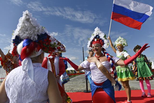 (260822) -- MOSCOW, Aug. 22, 2026 (Xinhua) -- Women wearing traditional Russian headdress pose for a photo with Russian national flag at the "Russian Field" Art Festival at Victory Park in Moscow, Russia, on Aug. 22, 2026. The 15th "Russian Field" Art Festival kicked off at Victory Park in Moscow, Russia, on Aug. 22. (Photo by Alexander Zemlianichenko Jr/Xinhua)