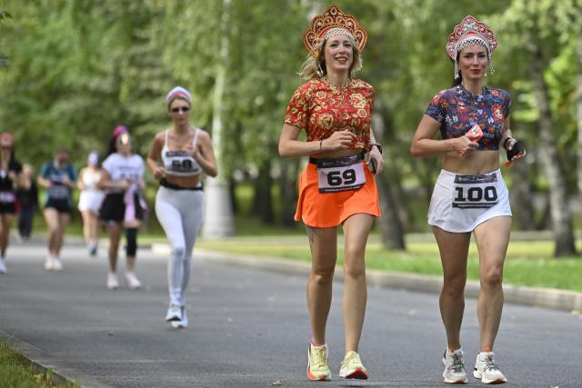 (260822) -- MOSCOW, Aug. 22, 2026 (Xinhua) -- Women wearing traditional Russian headdress participate in a running activity at the "Russian Field" Art Festival at Victory Park in Moscow, Russia, on Aug. 22, 2026. The 15th "Russian Field" Art Festival kicked off at Victory Park in Moscow, Russia, on Aug. 22. (Photo by Alexander Zemlianichenko Jr/Xinhua)