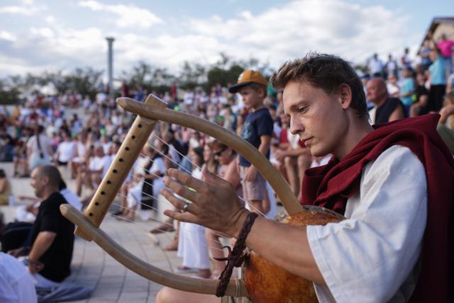 (260822) -- PTUJ, Aug. 22, 2026 (Xinhua) -- A participant dressed in Roman costume plays the lyra during the Roman Games Festival in Ptuj, Slovenia, Aug. 22, 2026. The 19th edition of the Roman Games festival kicked off on Friday in Ptuj and will last till Aug. 23. (Photo by Zeljko Stevanic/Xinhua)