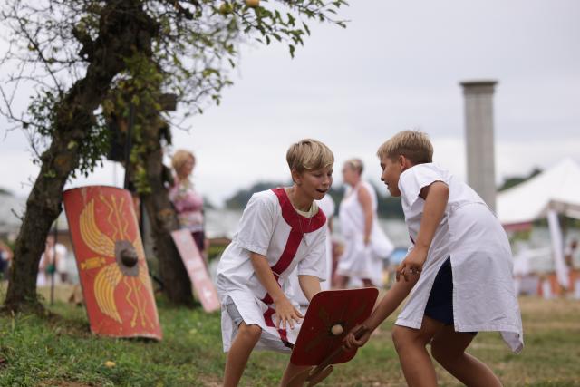 (260822) -- PTUJ, Aug. 22, 2026 (Xinhua) -- Boys dressed in Roman costumes play during the Roman Games Festival in Ptuj, Slovenia, Aug. 22, 2026. The 19th edition of the Roman Games festival kicked off on Friday in Ptuj and will last till Aug. 23. (Photo by Zeljko Stevanic/Xinhua)