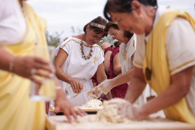 (260822) -- PTUJ, Aug. 22, 2026 (Xinhua) -- Participants dressed in Roman costumes attend a bread-making contest during the Roman Games Festival in Ptuj, Slovenia, Aug. 22, 2026. The 19th edition of the Roman Games festival kicked off on Friday in Ptuj and will last till Aug. 23. (Photo by Zeljko Stevanic/Xinhua)