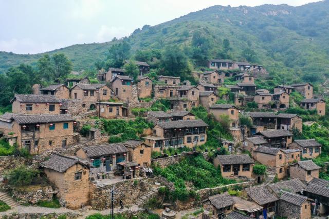 (260823) -- YANGQUAN, Aug. 23, 2026 (Xinhua) -- A drone photo taken on Aug. 21, 2026 shows a view of Dapin Village in Yuxian County, Yangquan City of north China's Shanxi Province. Dapin Village, located deep in Taihang Mountain, is a traditional village with a long history in Shanxi Province. The houses here are built mostly with a mixture of yellow clay and stone. More than 50 small courtyards are located on a protruding mountainside, layered from bottom to top, which presents a unique scenery. (Xinhua/Cao Yang)