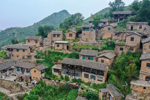 (260823) -- YANGQUAN, Aug. 23, 2026 (Xinhua) -- A drone photo taken on Aug. 21, 2026 shows a view of Dapin Village in Yuxian County, Yangquan City of north China's Shanxi Province. Dapin Village, located deep in Taihang Mountain, is a traditional village with a long history in Shanxi Province. The houses here are built mostly with a mixture of yellow clay and stone. More than 50 small courtyards are located on a protruding mountainside, layered from bottom to top, which presents a unique scenery. (Xinhua/Cao Yang)