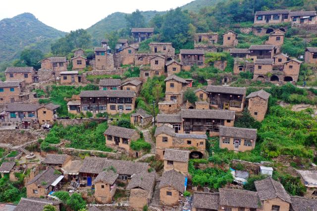 (260823) -- YANGQUAN, Aug. 23, 2026 (Xinhua) -- A drone photo taken on Aug. 21, 2026 shows a view of Dapin Village in Yuxian County, Yangquan City of north China's Shanxi Province. Dapin Village, located deep in Taihang Mountain, is a traditional village with a long history in Shanxi Province. The houses here are built mostly with a mixture of yellow clay and stone. More than 50 small courtyards are located on a protruding mountainside, layered from bottom to top, which presents a unique scenery. (Xinhua/Cao Yang)