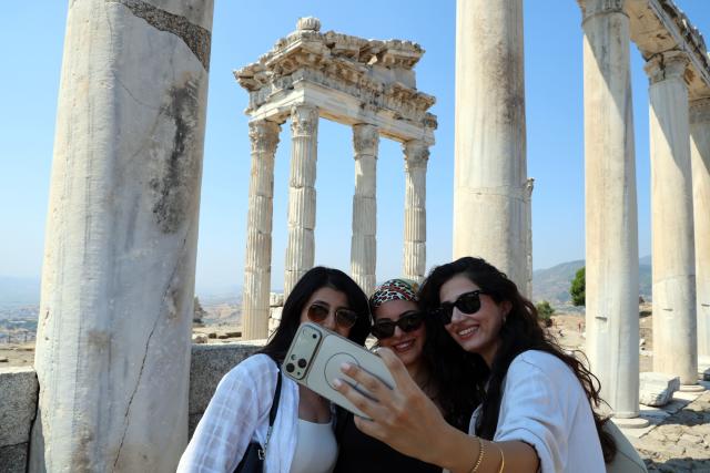 (260823) -- IZMIR, Aug. 23, 2026 (Xinhua) -- Tourists take selfies at the Bergama ancient city in Bakircay Basin in Izmir, Türkiye, on Aug. 22, 2026. Known as Pergamon in antiquity and designated a UNESCO World Heritage site, Bergama occupies a strategic position overlooking fertile lands and vital water resources. At its heart lies the Bergama Acropolis, a landmark distinguished by its multilayered history spanning the Hellenistic, Roman, Byzantine, Beylik, and Ottoman periods. (Mustafa Kaya/Handout via Xinhua)