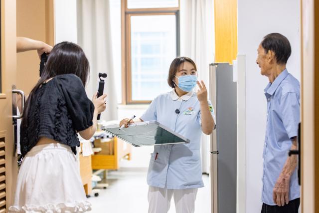 (260823) -- HUZHOU, Aug. 23, 2026 (Xinhua) -- Shen Wanting (C) gives instructions on acting to a senior resident at the Shushan Healthcare Center in Huzhou City, east China's Zhejiang Province, Aug. 11, 2026.
  Senior residents at the Shushan Healthcare Center, an elderly care center in Huzhou, Zhejiang Province, sometimes misunderstand one another during daily conversations because of their advanced age. These moments inspired Shen Wanting, a post-95 nurse, and five colleagues of similar age to create micro dramas featuring these elderly residents and their daily lives at the center. 
  Five senior residents, whose average age is over 80, are regular cast members, and the oldest is over 90. 
  After gaining attention online, the production team has continued to release micro drama episodes. Since June 2025, they have produced over 160 episodes. (Photo by Yi Fan/Xinhua)
