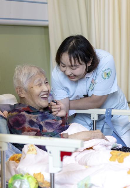 (260823) -- HUZHOU, Aug. 23, 2026 (Xinhua) -- Shen Wanting (R) and a senior resident are filmed during a video shoot at the Shushan Healthcare Center in Huzhou City, east China's Zhejiang Province, Aug. 11, 2026.
  Senior residents at the Shushan Healthcare Center, an elderly care center in Huzhou, Zhejiang Province, sometimes misunderstand one another during daily conversations because of their advanced age. These moments inspired Shen Wanting, a post-95 nurse, and five colleagues of similar age to create micro dramas featuring these elderly residents and their daily lives at the center. 
  Five senior residents, whose average age is over 80, are regular cast members, and the oldest is over 90. 
  After gaining attention online, the production team has continued to release micro drama episodes. Since June 2025, they have produced over 160 episodes. (Photo by Yi Fan/Xinhua)