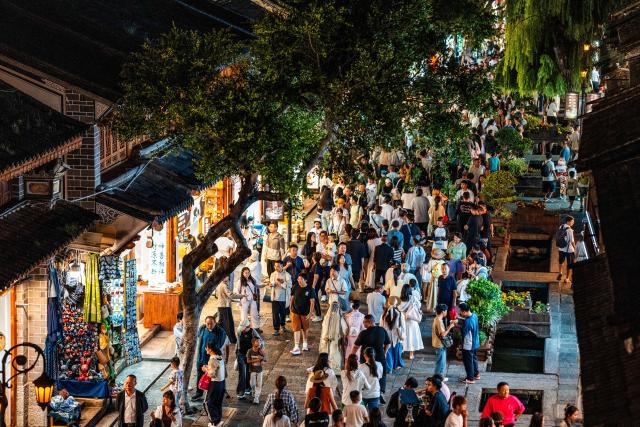 (260823) -- DALI, Aug. 23, 2026 (Xinhua) -- Tourists visit the ancient town of Dali in Dali, southwest China's Yunnan Province, Aug. 20, 2026. The ancient town of Dali has entered its peak tourism season during the summer holiday. According to the ancient town protection and management department, the ancient town recorded over 22 million tourist trips in the first seven months of 2026. (Xinhua/Hu Chao)