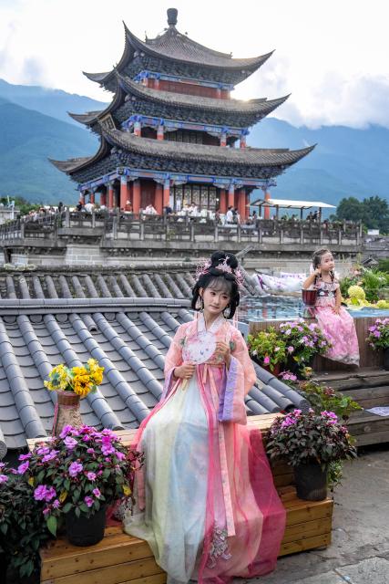 (260823) -- DALI, Aug. 23, 2026 (Xinhua) -- Tourists pose for photos at the ancient town of Dali in Dali, southwest China's Yunnan Province, Aug. 22, 2026. The ancient town of Dali has entered its peak tourism season during the summer holiday. According to the ancient town protection and management department, the ancient town recorded over 22 million tourist trips in the first seven months of 2026. (Xinhua/Hu Chao)