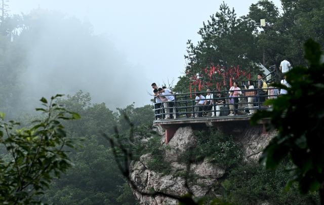 (260823) -- JIYUAN, Aug. 23, 2026 (Xinhua) -- Tourists visit the Wangwu Mountain scenic spot in Jiyuan, central China's Henan Province, Aug. 22, 2026. The Wangwu Mountain scenic spot witnesses a tourism boom during the summer vacation. (Xinhua/Zhu Xiang)