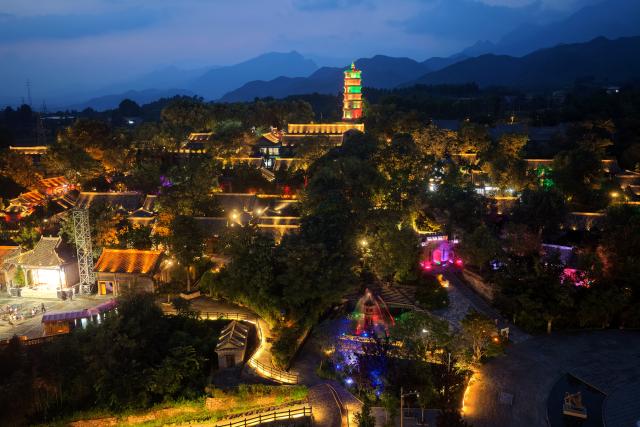 (260823) -- JIYUAN, Aug. 23, 2026 (Xinhua) -- This aerial drone photo taken on Aug. 21, 2026 shows a night view of a night market in the Wangwu ancient street in Yugong Village of Jiyuan, central China's Henan Province. The Wangwu Mountain scenic spot witnesses a tourism boom during the summer vacation. (Photo by Duan Erping/Xinhua)