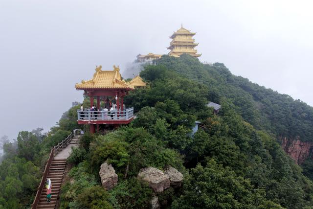 (260823) -- JIYUAN, Aug. 23, 2026 (Xinhua) -- This drone photo shows tourists visiting the Wangwu Mountain scenic spot in Jiyuan, central China's Henan Province, Aug. 22, 2026. The Wangwu Mountain scenic spot witnesses a tourism boom during the summer vacation. (Photo by Duan Erping/Xinhua)