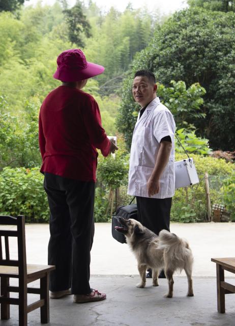 (260823) -- JINZHAI, Aug. 23, 2026 (Xinhua) -- Doctor Yu Jiajun (R) explains medication precautions to villager Wang Jiabi during his home visit in Qishan Village of Mabu Town, Jinzhai County of Lu'an City, east China's Anhui Province, June 26, 2026. Haidao Village of Qishan Village is located deep in the mountains near the Xianghongdian Reservoir area in Jinzhai County of Lu'an City, east China's Anhui Province. Yu Jiajun, the only village doctor, takes charge of health care for more than 500 villagers there and in the surrounding areas.
   In the past, there was no clinic. Villagers had to row a boat for two or three hours to go to the health center in the Mabu Town to see the doctor. 
   After graduating from a medical school, following his father's last wishes, Yu Jiajun gave up his job in the city and returned to the village where he was born to work as a village doctor in the year of 2000. In order to visit his patients timely, Yu and his wife set up their home on a wooden boat, named "Haidao Clinic," and provided medical care to villagers on the boat.
   In recent years, many changes have taken place. The clinic was rebuilt in 2019. With the help of the local government, a standardized diagnosis and treatment building was set up on the shore. Yu's work focus has also shifted from emergency treatment in the past to offering medical service for chronic diseases. 
   However, Yu still need to drive his boat to make visits, as he has been always doing in the past years. Since working as the village doctor, he has changed four boats, conducting more than 20,000 medical consultations at patients' home. 
   Yu joined the Communist Party of China (CPC) in 2014. As a village doctor, he has been fulfilling his own promise to his father and taking the responsibility as a member of the Communist Party. 
   "As long as people need me, I will keep working here," Yu said. (Xinhua/Zhang Duan)