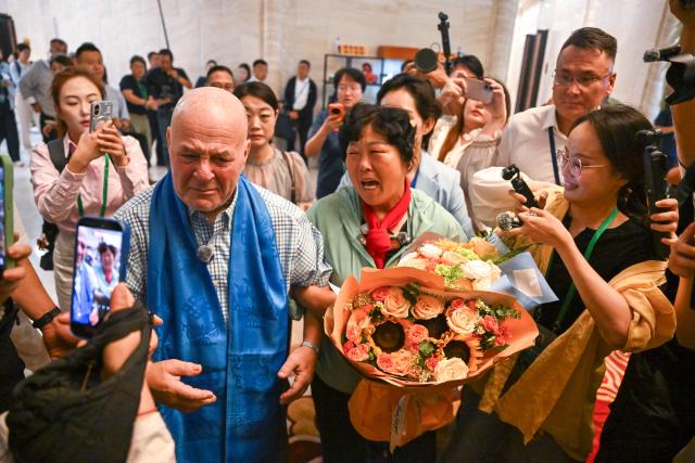 (260823) -- ORDOS, Aug. 23, 2026 (Xinhua) -- Yin Yuzhen is reunited with Ronald Sakolsky at an airport in Ordos, north China's Inner Mongolia Autonomous Region, Aug. 23, 2026.
  Retired U.S. teacher Ronald Sakolsky, who once supported China's desertification control efforts, arrived in Ordos on Sunday and was reunited with his friend Yin Yuzhen, a national model worker who has been planting trees in the Maowusu Sandy Land for four decades.
  Their story began in 1999, when Sakolsky taught English at a school in central China's Henan Province under a teachers' exchange program between the two countries.
  After watching a television news report featuring Yin's tireless work, he was deeply moved and raised 5,000 U.S. dollars to help Yin and her husband in their afforestation efforts against desertification.
  The saplings bought and planted with that donation have since grown into a forest of more than 50,000 towering trees. (Xinhua/Lian Zhen)