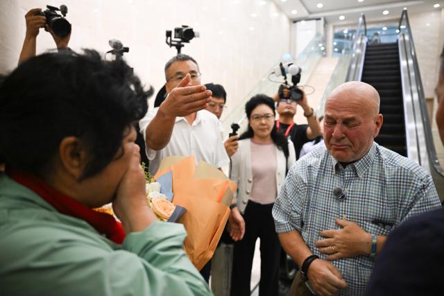 (260823) -- ORDOS, Aug. 23, 2026 (Xinhua) -- Yin Yuzhen is reunited with Ronald Sakolsky at an airport in Ordos, north China's Inner Mongolia Autonomous Region, Aug. 23, 2026.
  Retired U.S. teacher Ronald Sakolsky, who once supported China's desertification control efforts, arrived in Ordos on Sunday and was reunited with his friend Yin Yuzhen, a national model worker who has been planting trees in the Maowusu Sandy Land for four decades.
  Their story began in 1999, when Sakolsky taught English at a school in central China's Henan Province under a teachers' exchange program between the two countries.
  After watching a television news report featuring Yin's tireless work, he was deeply moved and raised 5,000 U.S. dollars to help Yin and her husband in their afforestation efforts against desertification.
  The saplings bought and planted with that donation have since grown into a forest of more than 50,000 towering trees. (Xinhua/Lian Zhen)