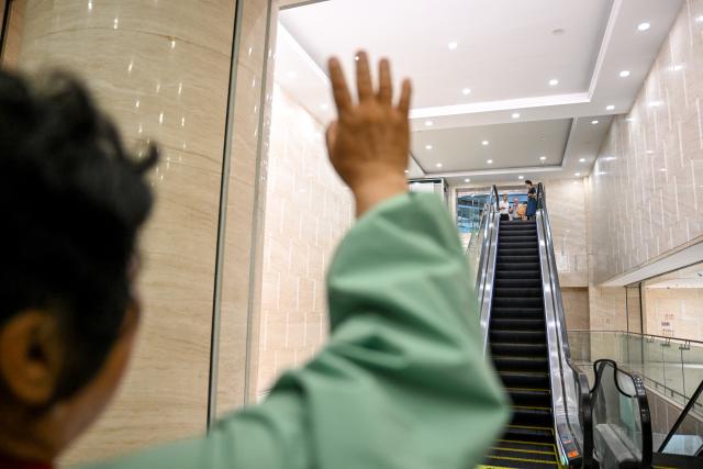 (260823) -- ORDOS, Aug. 23, 2026 (Xinhua) -- Yin Yuzhen waves to Ronald Sakolsky at an airport in Ordos, north China's Inner Mongolia Autonomous Region, Aug. 23, 2026.
  Retired U.S. teacher Ronald Sakolsky, who once supported China's desertification control efforts, arrived in Ordos on Sunday and was reunited with his friend Yin Yuzhen, a national model worker who has been planting trees in the Maowusu Sandy Land for four decades.
  Their story began in 1999, when Sakolsky taught English at a school in central China's Henan Province under a teachers' exchange program between the two countries.
  After watching a television news report featuring Yin's tireless work, he was deeply moved and raised 5,000 U.S. dollars to help Yin and her husband in their afforestation efforts against desertification.
  The saplings bought and planted with that donation have since grown into a forest of more than 50,000 towering trees. (Xinhua/Lian Zhen)