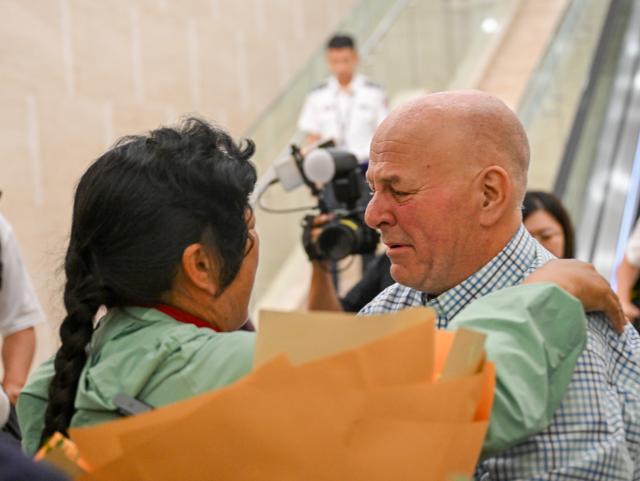 (260823) -- ORDOS, Aug. 23, 2026 (Xinhua) -- Yin Yuzhen is reunited with Ronald Sakolsky at an airport in Ordos, north China's Inner Mongolia Autonomous Region, Aug. 23, 2026.
  Retired U.S. teacher Ronald Sakolsky, who once supported China's desertification control efforts, arrived in Ordos on Sunday and was reunited with his friend Yin Yuzhen, a national model worker who has been planting trees in the Maowusu Sandy Land for four decades.
  Their story began in 1999, when Sakolsky taught English at a school in central China's Henan Province under a teachers' exchange program between the two countries.
  After watching a television news report featuring Yin's tireless work, he was deeply moved and raised 5,000 U.S. dollars to help Yin and her husband in their afforestation efforts against desertification.
  The saplings bought and planted with that donation have since grown into a forest of more than 50,000 towering trees. (Xinhua/Lian Zhen)