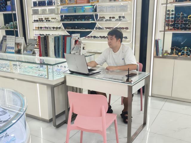 (260823) -- CHENGDU, Aug. 23, 2026 (Xinhua) -- Chen Aijun works in an optical shop in Chengdu, southwest China's Sichuan Province, Aug. 14, 2026.
  TO GO WITH "Feature: When a Chinese mythic world travels without translation" (Xinhua/Lu Youyi)