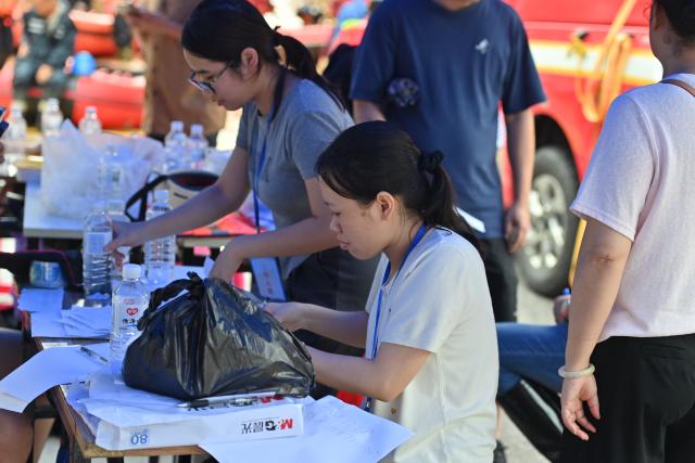 (260823) -- NINGMING, Aug. 23, 2026 (Xinhua) -- Transferred residents register their information in Ningming County, south China's Guangxi Zhuang Autonomous Region, Aug. 23, 2026. For days, Ningming County has been battered by typhoon-triggered heavy rainfall. Response forces have pooled their efforts to urgently evacuate stranded residents. (Xinhua/Zhou Hua)