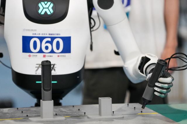(260823) -- BEIJING, Aug. 23, 2026 (Xinhua) -- The robot of Beijing Humanoid-BJTU-Qiangnao Zhixing Joint Team competes during the final of Power Tool Assembly of the 2nd World Humanoid Robot Games in Beijing, capital of China, Aug. 23, 2026. (Xinhua/Ju Huanzong)