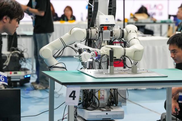 (260823) -- BEIJING, Aug. 23, 2026 (Xinhua) -- The robot of Lingxin Qiaoshou competes during the final of Power Tool Assembly of the 2nd World Humanoid Robot Games in Beijing, capital of China, Aug. 23, 2026. (Xinhua/Ju Huanzong)