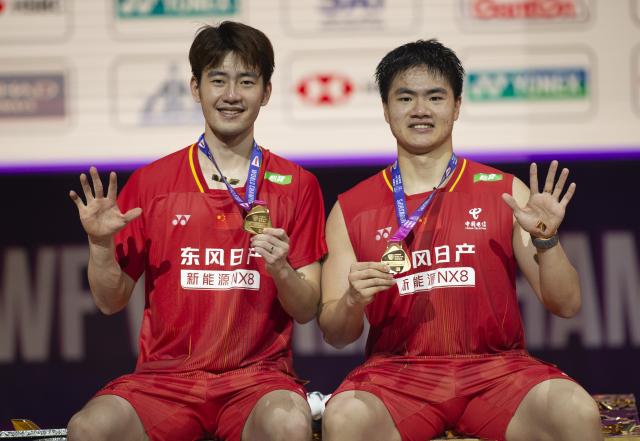 (260823) -- NEW DELHI, Aug. 23, 2026 (Xinhua) -- Gold medalists Wang Chang (L) and Liang Weikeng of China pose on the podium after the men's doubles final between Wang Chang/Liang Weikeng of China and Aaron Chia/Soh Wooi Yik of Malaysia at BWF World Championships in New Delhi, Aug. 23, 2026. (Xinhua/Javed Dar)