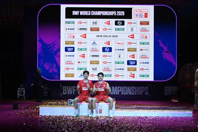 (260823) -- NEW DELHI, Aug. 23, 2026 (Xinhua) -- Gold medalists Wang Chang (L) and Liang Weikeng of China pose on the podium after the men's doubles final between Wang Chang/Liang Weikeng of China and Aaron Chia/Soh Wooi Yik of Malaysia at BWF World Championships in New Delhi, Aug. 23, 2026. (Xinhua/Javed Dar)
