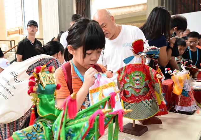(260823) -- FUZHOU, Aug. 23, 2026 (Xinhua) -- Visitors learn to make traditional handicrafts at the Jinsha Academy in Xiamen, southeast China's Fujian Province, Aug. 21, 2026.
  Leveraging its rich historical and cultural heritage, the city of Xiamen has strived to bring traditional heritage into modern-day life and developed a range of cultural spaces that blend ancient traditions with modern styles. (Xinhua/Lin Shanchuan)