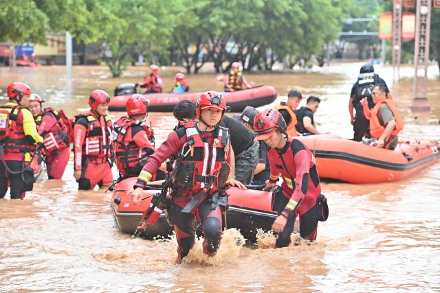 (260824) -- BEIJING, Aug. 24, 2026 (Xinhua) -- Rescuers transfer stranded residents in Ningming County, south China's Guangxi Zhuang Autonomous Region, Aug. 23, 2026. For days, Ningming County has been battered by typhoon-triggered heavy rainfall. Response forces have pooled their efforts to urgently evacuate stranded residents. (Xinhua/Zhou Hua)