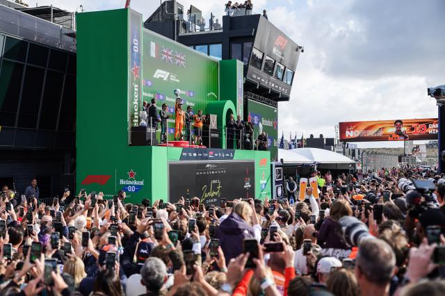 (260824) -- ZANDVOORT, Aug. 24, 2026 (Xinhua) -- McLaren's British driver Lando Norris (C) celebrates with the trophy during the awarding ceremony after the Formula 1 Dutch Grand Prix Race at Zandvoort Circuit, near Amsterdam, the Netherlands, Aug. 23, 2026. (Xinhua/Peng Ziyang)