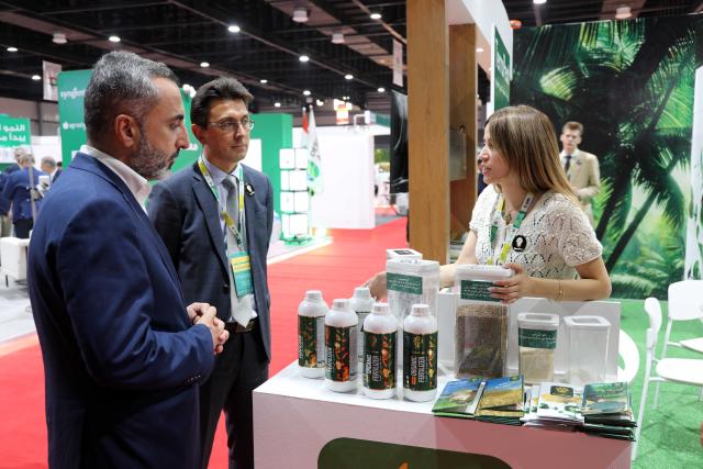 (260824) -- BAGHDAD, Aug. 24, 2026 (Xinhua) -- Two men talk with an exhibitor at the 17th Agricultural Week exhibition in Baghdad, Iraq, on Aug. 23, 2026. The 17th Agricultural Week exhibition is running from Saturday to Thursday in Iraq's capital city of Baghdad. (Xinhua/Khalil Dawood)