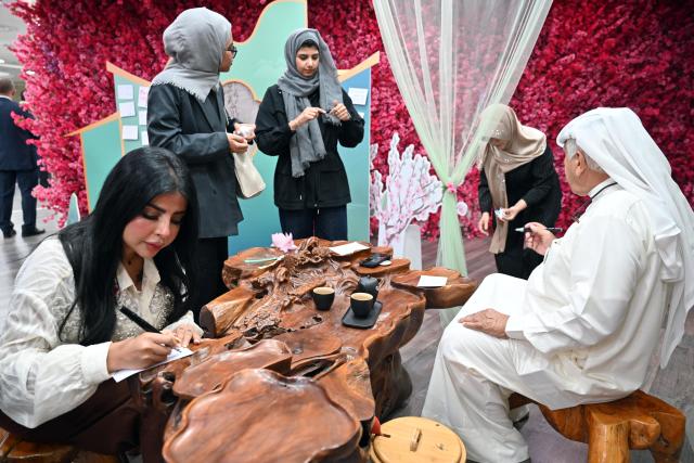 (260824) -- KUWAIT CITY, Aug. 24, 2026 (Xinhua) -- People participate in the Chinese & Kuwaiti Tea Art and Treats Tasting event at the China Cultural Center in Kuwait in Hawalli Governorate, Kuwait, Aug. 23, 2026. More than 150 people gathered Sunday evening here for the event, where they savored teas and sweets and learned about tea-making traditions in both countries.
   Jointly organized by the China Cultural Center in Kuwait and Kuwait's National Council for Culture, Arts and Letters (NCCAL), the event was part of Kuwait's 18th Summer Cultural Festival. It aimed to introduce Chinese and Kuwaiti tea traditions and promote cultural and people-to-people exchanges between the two countries. (Photo by Asad/Xinhua)