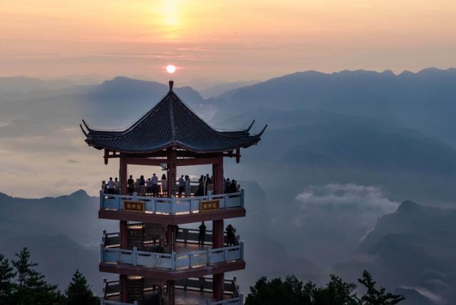 (260824) -- GUANGYUAN, Aug. 24, 2026 (Xinhua) -- An aerial drone photo taken on Aug. 23, 2026 shows tourists enjoying sunrise scenery in Zengjiashan scenic spot of Guangyuan City, southwest China's Sichuan Province. Zengjiashan, a summer getaway with an average elevation of 1,300 meters and summer temperatures of around 23 degrees centigrade, is developing tourism by making the most of its cool climate, attracting visitors from surrounding areas. (Xinhua/Jiang Hongjing)