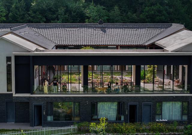 (260824) -- GUANGYUAN, Aug. 24, 2026 (Xinhua) -- A drone photo taken on Aug. 23, 2026 shows tourists resting at a homestay in Zengjiashan scenic spot of Guangyuan City, southwest China's Sichuan Province. Zengjiashan, a summer getaway with an average elevation of 1,300 meters and summer temperatures of around 23 degrees centigrade, is developing tourism by making the most of its cool climate, attracting visitors from surrounding areas. (Xinhua/Jiang Hongjing)