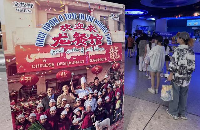 (260824) -- QINGDAO, Aug. 24, 2026 (Xinhua) -- Spectators line up for ticket check next to a poster of the film "Once Upon a Time in the Middle East" at a cinema in Qingdao, east China's Shandong Province, Aug. 24, 2026. (Xinhua/Li Ziheng)