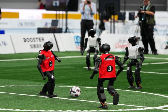 (260824) -- BEIJING, Aug. 24, 2026 (Xinhua) -- Robots (L) of CAU Mountain&Sea competes with robots of B-human during the 5v5 Medium Robot Group of Soccer match of the 2nd World Humanoid Robot Games in Beijing, capital of China, Aug. 24, 2026. (Xinhua/Ju Huanzong)