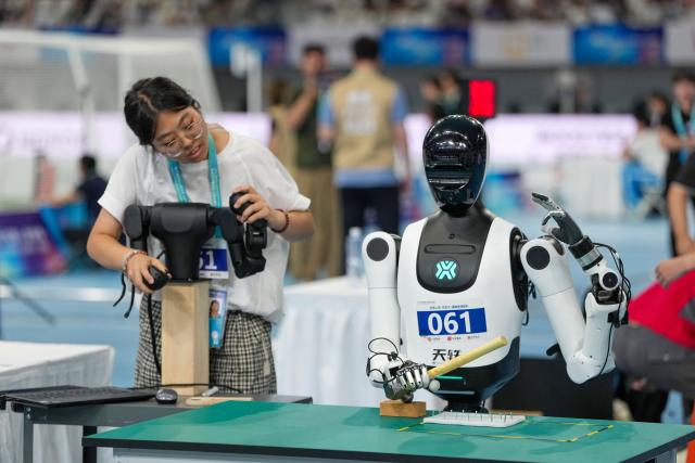 (260824) -- BEIJING, Aug. 24, 2026 (Xinhua) -- The robot of Beijing Humanoid·BJTU·Strong Mind Siyuan Team competes during the Nail Fastening competition of the 2nd World Humanoid Robot Games in Beijing, capital of China, Aug. 24, 2026. (Xinhua/Ju Huanzong)