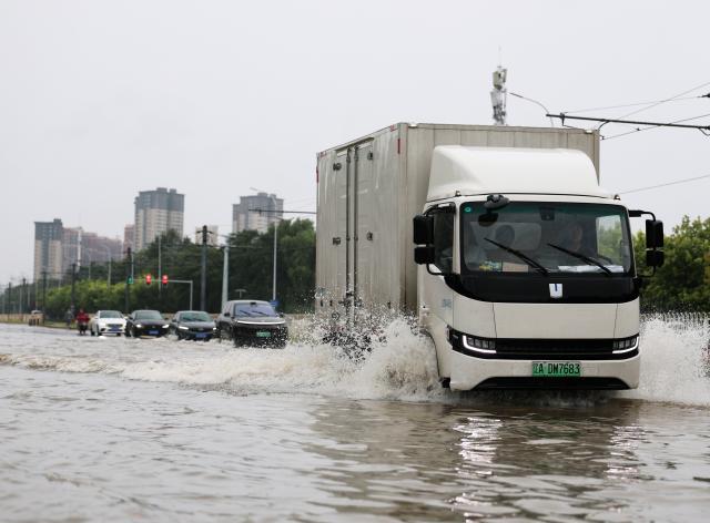(260824) -- SHENYANG, Aug. 24, 2026 (Xinhua) -- Vehicles drive through a waterlogged street in Shenyang, northeast China's Liaoning Province, Aug. 24, 2026. Heavy to torrential rains lashed southeastern Liaoning from 8 a.m. Sunday to 11 a.m. Monday, with downpours in some areas, while northern and western parts of the province saw light to moderate rain and localized heavy to torrential rains in a few spots.
Red alerts for torrential rain remain in effect across multiple parts of Liaoning. As of 6 a.m. Monday, nine cities had activated flood emergency responses, according to the provincial flood control and drought relief headquarters. (Xinhua/Li Gang)