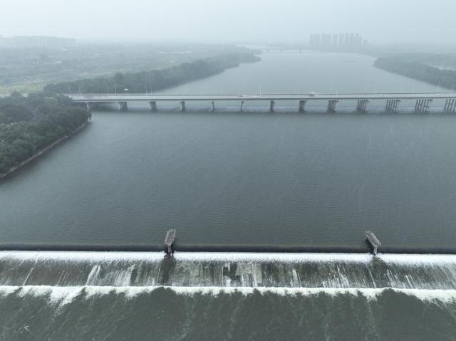 (260824) -- SHENYANG, Aug. 24, 2026 (Xinhua) -- An aerial drone photo taken on Aug. 24, 2026 shows the Hunhe River in Shenyang, northeast China's Liaoning Province. Heavy to torrential rains lashed southeastern Liaoning from 8 a.m. Sunday to 11 a.m. Monday, with downpours in some areas, while northern and western parts of the province saw light to moderate rain and localized heavy to torrential rains in a few spots.
Red alerts for torrential rain remain in effect across multiple parts of Liaoning. As of 6 a.m. Monday, nine cities had activated flood emergency responses, according to the provincial flood control and drought relief headquarters. (Xinhua/Li Gang)