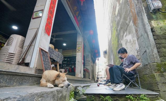 (260825) -- NANCHANG, Aug. 25, 2026 (Xinhua) -- Tourists sketch in Likeng Village of Wuyuan County, east China's Jiangxi Province, Aug. 25, 2026. Likeng Village, nestled among the mountains of northeastern Jiangxi Province where ancient Huizhou cultural heritage meets idyllic pastoral scenery, sees a surge of sketch-painting visitors in early autumn. (Xinhua/Hu Chenhuan)