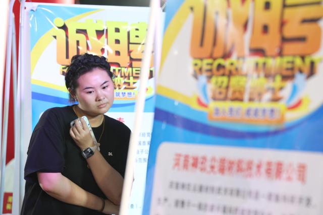 (260825) -- BEIJING, Aug. 25, 2026 (Xinhua) -- A job seeker views recruitment information at a job fair in Jiaozuo City of central China's Henan Province, Aug. 8, 2026. A series of job fairs have been held across the country during the summer vacation and vocational training courses are also being offered in many places to advance employment. (Photo by Xu Hongxing/Xinhua)