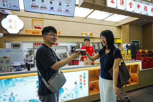 (260825) -- JINAN, Aug. 25, 2026 (Xinhua) -- Visitors taste ejiao coffee in Hongjitang TCM Culture & Tourism Resort in Jinan, east China's Shandong Province, Aug. 24, 2026. Donkey-hide gelatin, known as ejiao in Chinese, is a kind of traditional Chinese medicine and health food. Founded in 1907, Shandong Hongjitang Pharmaceutical Group Co., Ltd. adheres to the mission of inheriting the essence of traditional Chinese medicine (TCM) making and popularizing TCM culture. It has built Hongjitang TCM Culture & Tourism Resort which provides educational study tours as well as leisure activities. Visitors can observe TCM production process during sightseeing tours and try on making herbal drinks by themselves in its demonstration halls. (Xinhua/Dai Mingxuan)