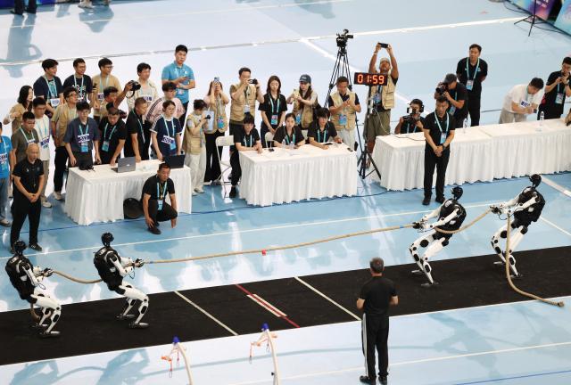 (260825) -- BEIJING, Aug. 25, 2026 (Xinhua) -- Robots of Tiangong Team (R) compete with Beijing Humanoid - Hust Joint Team during the heavyweight Tug of War of the 2nd World Humanoid Robot Games in Beijing, capital of China, Aug. 25, 2026. (Xinhua/Zhang Chenlin)