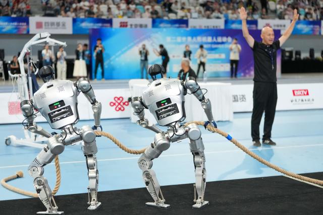 (260825) -- BEIJING, Aug. 25, 2026 (Xinhua) -- Robots of Xingzhe Taishan compete during the lightweight Tug of War of the 2nd World Humanoid Robot Games in Beijing, capital of China, Aug. 25, 2026. (Xinhua/Ju Huanzong)