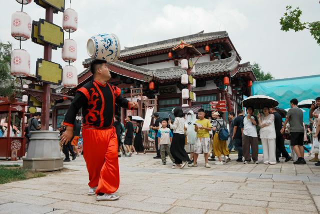 (260827) -- LAOLING, Aug. 27, 2026 (Xinhua) -- Tourists watch a performance at the Laoling Film Studio in Laoling City, east China's Shandong Province, Aug. 25, 2026.
  Laoling Film Studio, with its themed sets such as a 1:1 replica of San Francisco's Chinatown in 1900 and the prosperous Chang'an West Market of the Tang Dynasty (618-907), has become a new landmark for film and a driving force of the film industry on tourism in Shandong Province. More than 50 productions have been filmed here. (Xinhua/Dai Mingxuan)