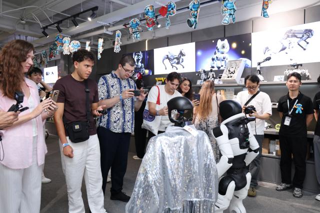 (260827) -- BEIJING, Aug. 27, 2026 (Xinhua) -- Members of a joint China-Russia media delegation watch a robot performance at a robot 6S store in Longgang District of Shenzhen, south China's Guangdong Province, Aug. 26, 2026.
  The delegation visited Hangzhou, Wuhan and Shenzhen in recent days to learn about the AI robotics industry. (Xinhua/Liang Xu)