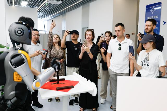 (260827) -- BEIJING, Aug. 27, 2026 (Xinhua) -- Members of a joint China-Russia media delegation watch a performance at a humanoid robot innovation center in Wuhan, central China's Hubei Province, Aug. 25, 2026.
  The delegation visited Hangzhou, Wuhan and Shenzhen in recent days to learn about the AI robotics industry. (Xinhua/Wu Zhizun)